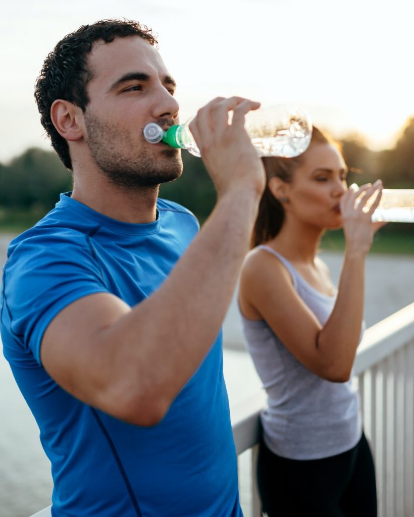 Athletic couple drinking water